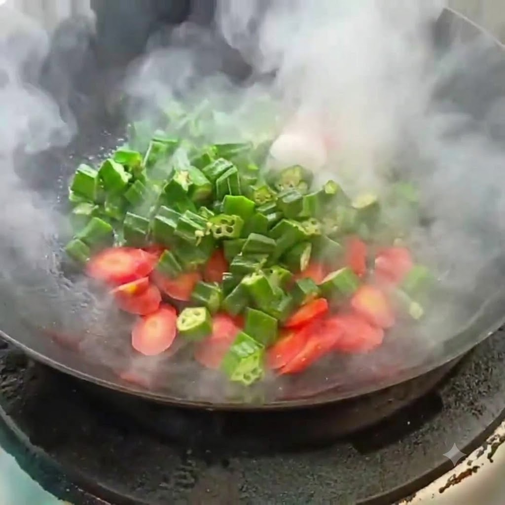 Okra affettata e carota saltate in un wok caldo con vapore in salita.