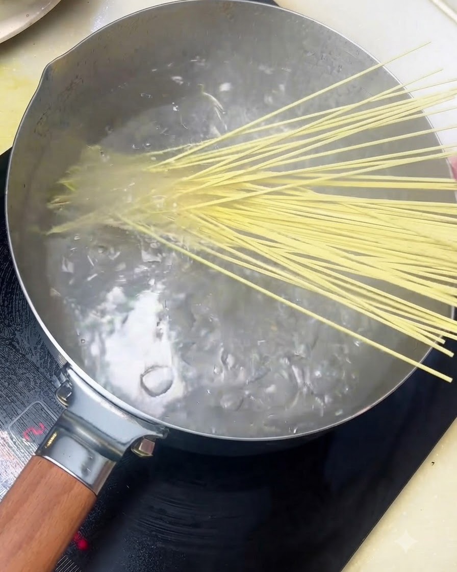 Noodles alcalini aggiunti in una pentola di acqua bollente.