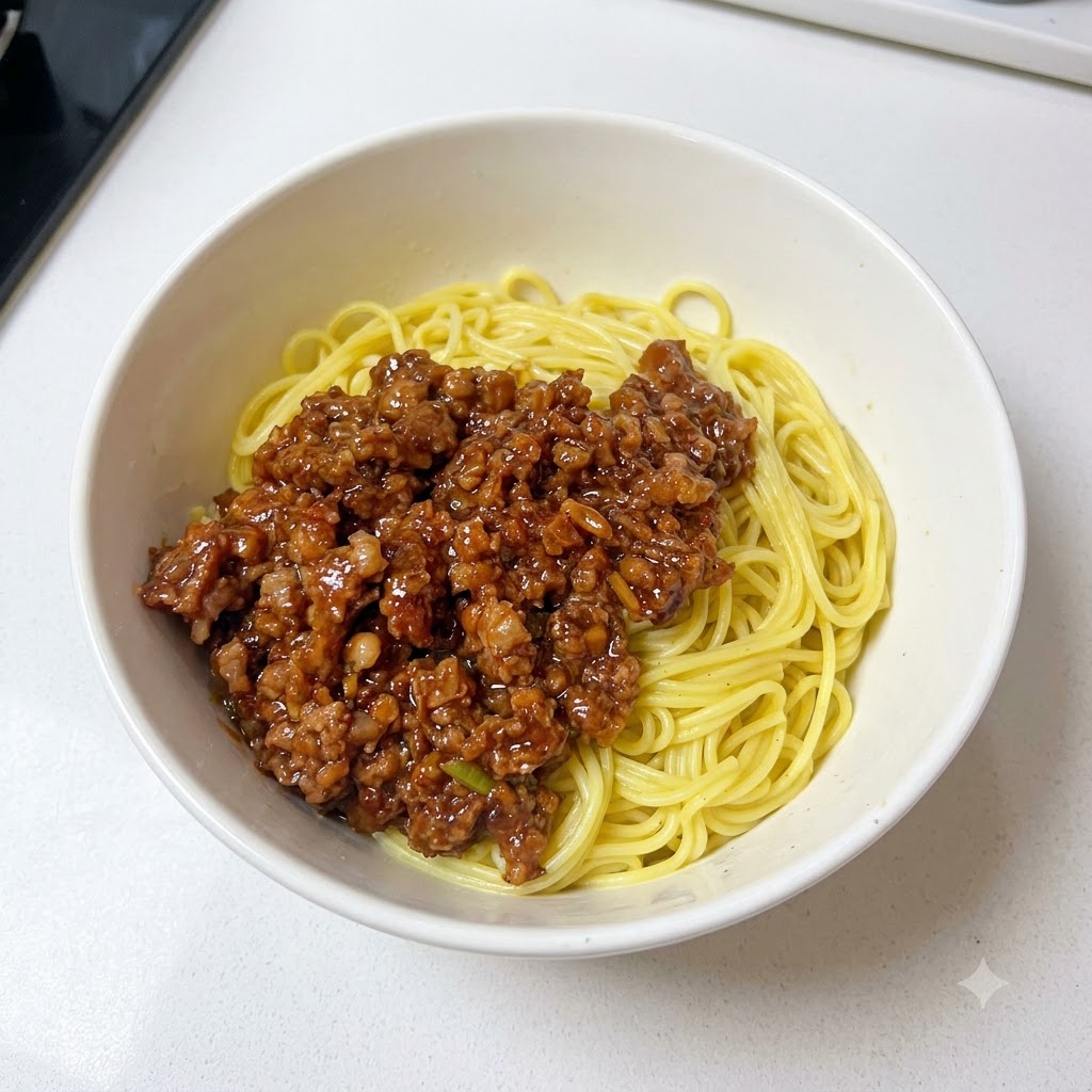 Una ciotola contenente noodles e salsa di carne macinata guarnita con cipollotti freschi tritati.