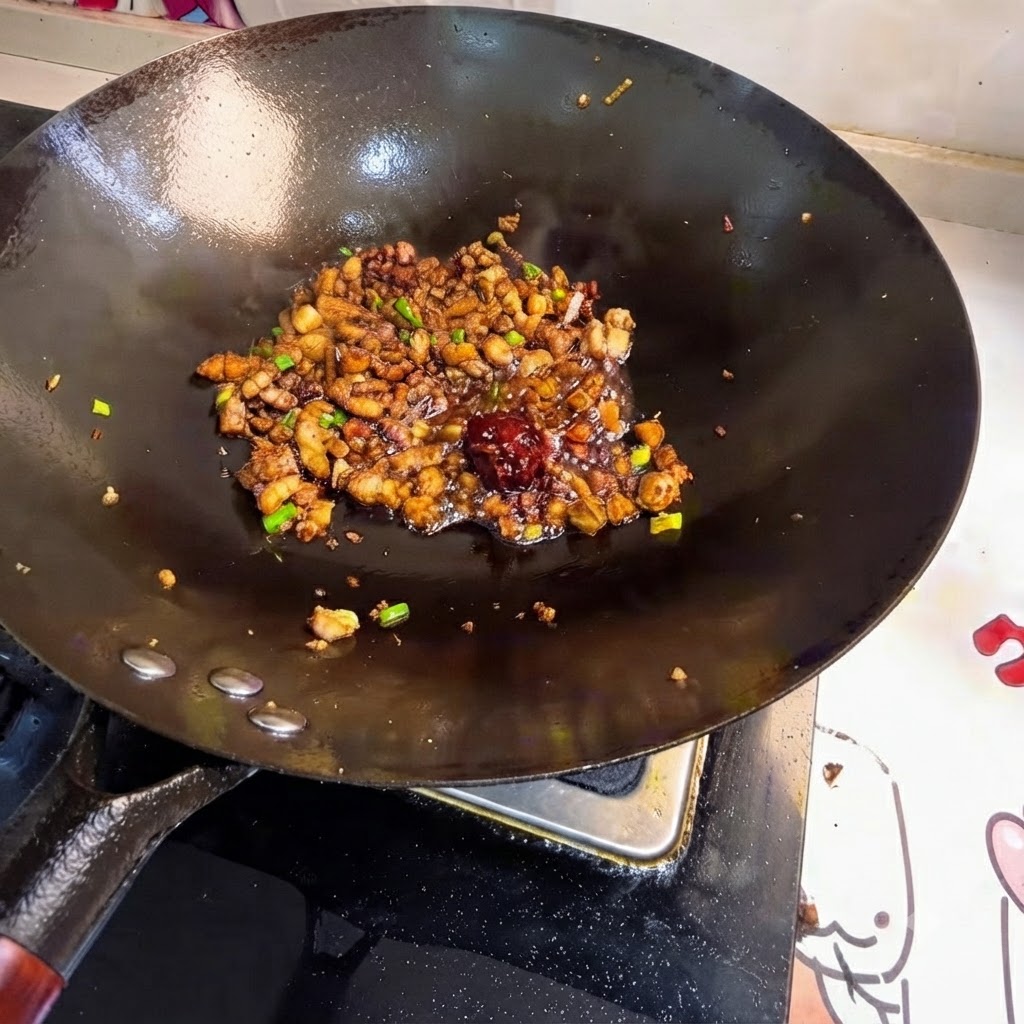 Mucchio di pasta di fagioli posizionato tra la carne saltata nel wok.