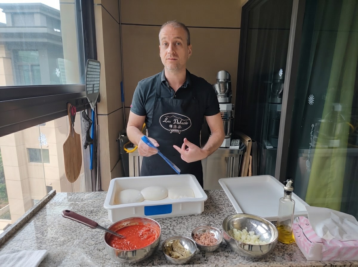 Un uomo che usa un utensile blu per sollevare una pallina dimpasto da una cassetta di lievitazione.