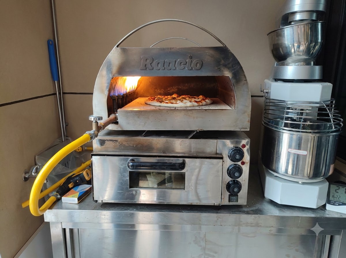 Una pizza cruda che cuoce allinterno di un forno per pizza da banco in acciaio inossidabile con una brillante fiamma viva sul retro.
