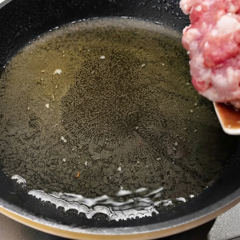 Maiale a cubetti trasferito in una padella calda per iniziare la cottura.