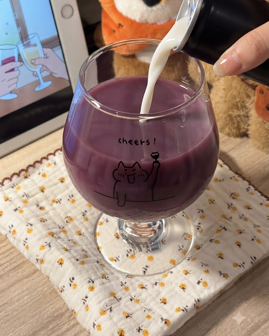 Latte bianco versato in un bicchiere pieno di succo duva viola, creando una miscela viola cremosa.