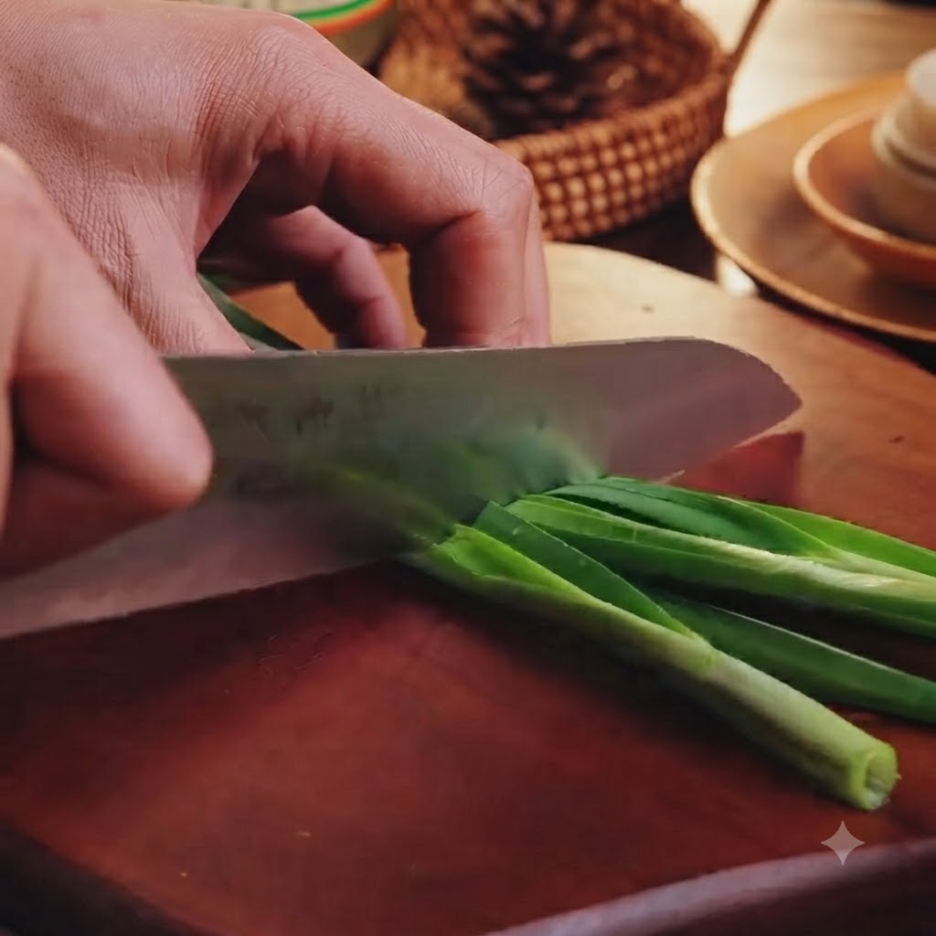 Tagliare lerba cipollina verde a piccoli pezzi su un tagliere di legno con un coltello da cucina.