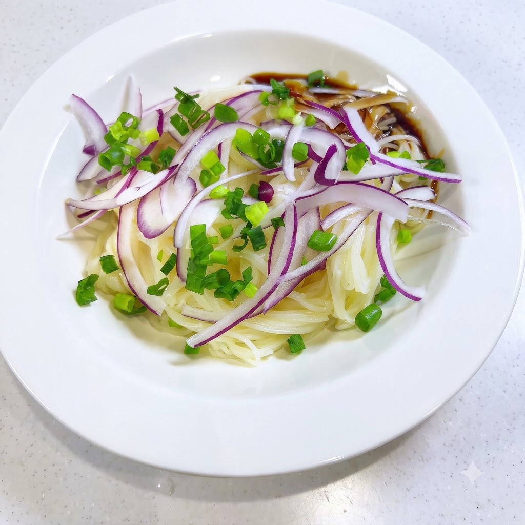 Salsa scura e saporita che viene versata sul lato dei noodles somen e delle cipolle in una ciotola bianca.