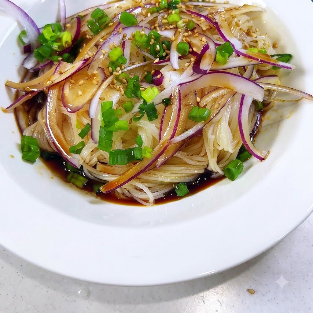 Semi di sesamo che vengono cosparsi sui noodles conditi, sulle cipolle e sulla salsa.