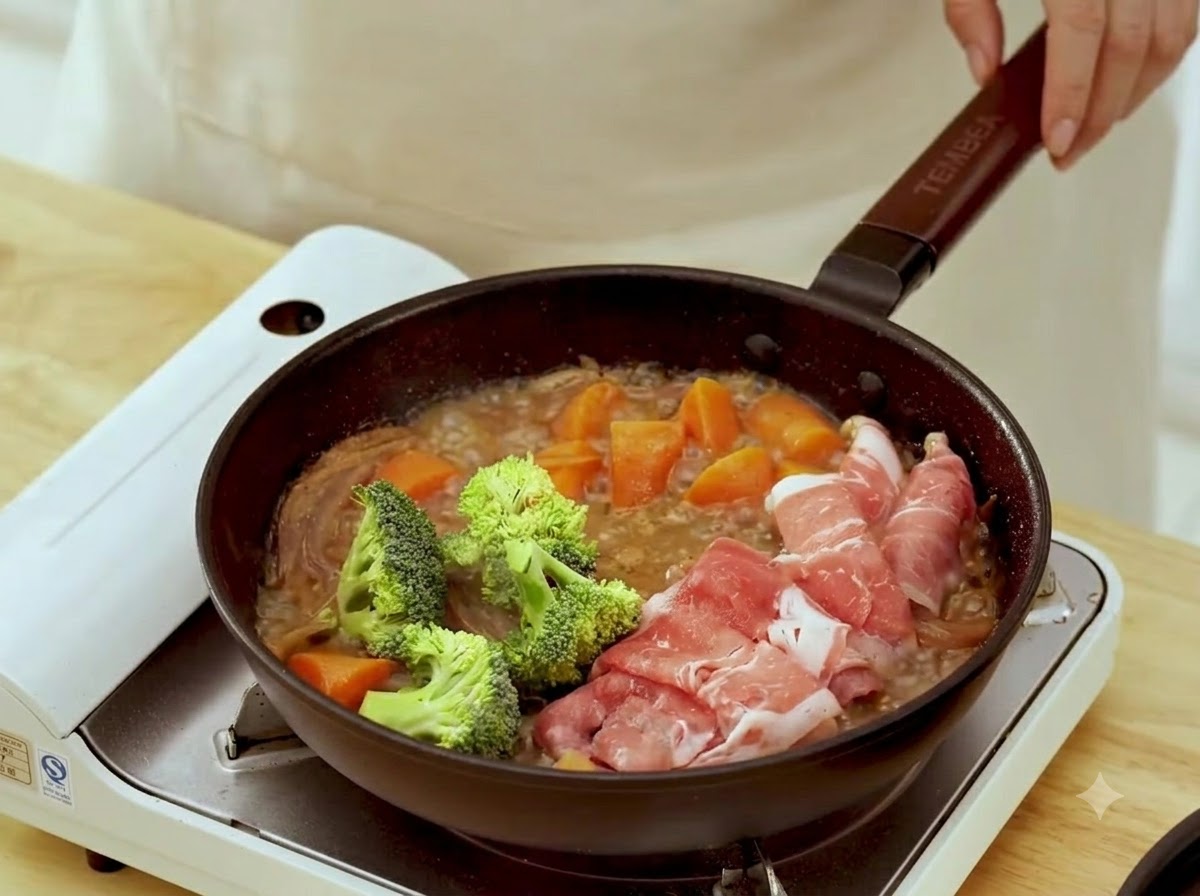Cimette di broccoli verdi freschi aggiunte nella padella vicino alle fette di manzo in cottura.