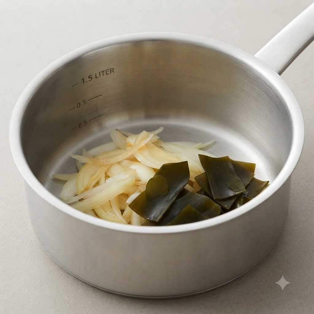 Una pentola da cucina contenente cipolle cotte e morbide accanto a un nodo di alga kelp ripiegato.