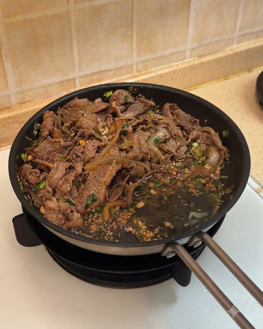 Due uova rotte nella padella accanto al manzo cotto e alle cipolle nella salsa.