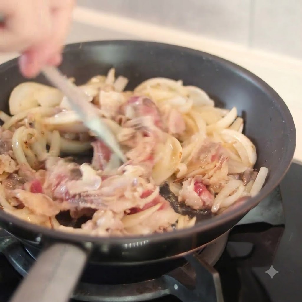 Una salsa scura versata dallalto in una padella calda contenente cipolle affettate e pezzi di manzo mentre viene mescolata con una spatola.