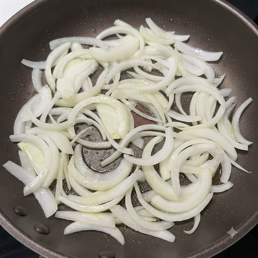 Listarelle di cipolla saltate in una padella calda finché i bordi non sono leggermente dorati.
