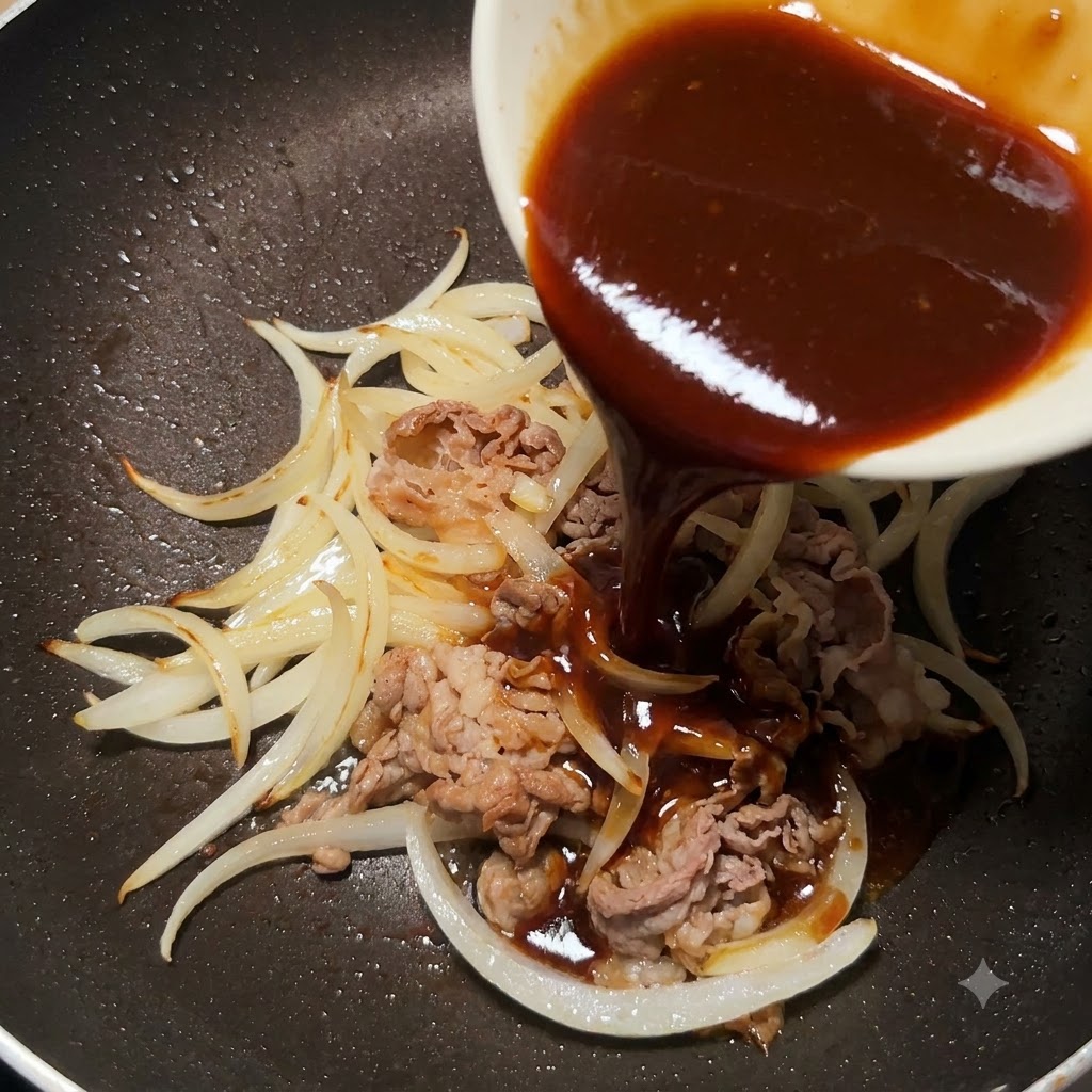Salsa teriyaki densa versata da una piccola ciotola bianca in una padella con manzo a fettine e cipolle cotte.
