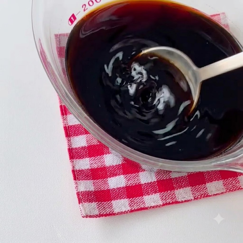 Pezzi di pollo marinati che sfrigolano in una padella calda unta dolio e vengono mescolati con un cucchiaio.