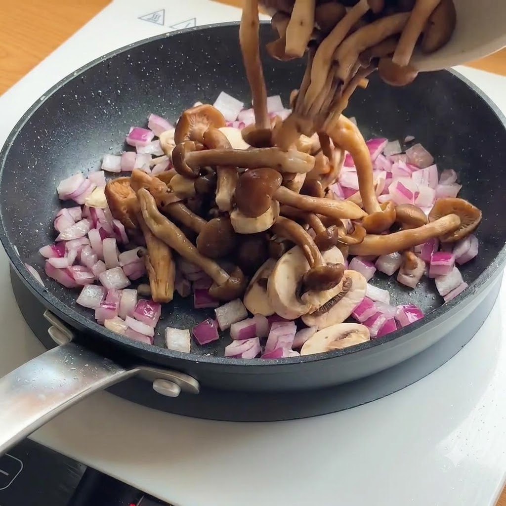 Funghi affettati e cipolle rosse aggiunti in una padella con i pezzi di pollo già dorati.