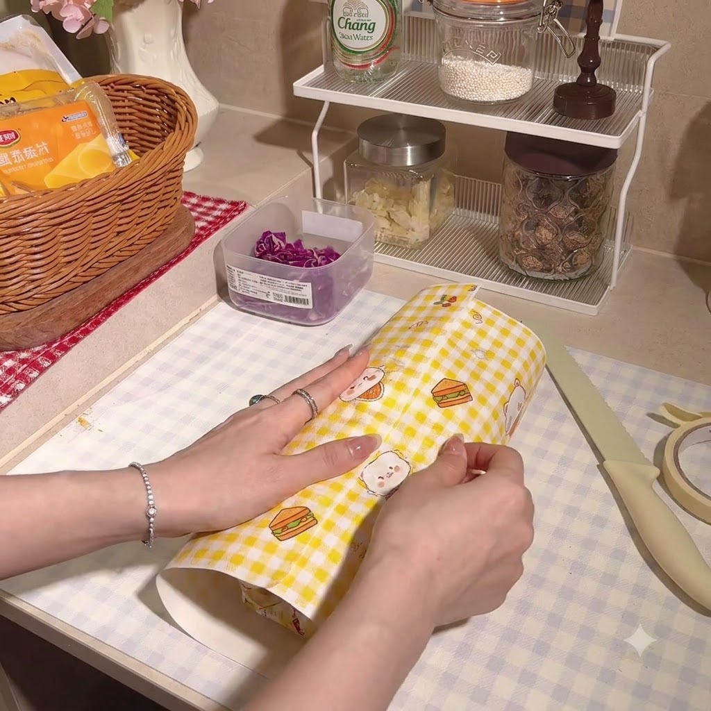 Il panino alto avvolto saldamente allinterno di carta da forno a scacchi.