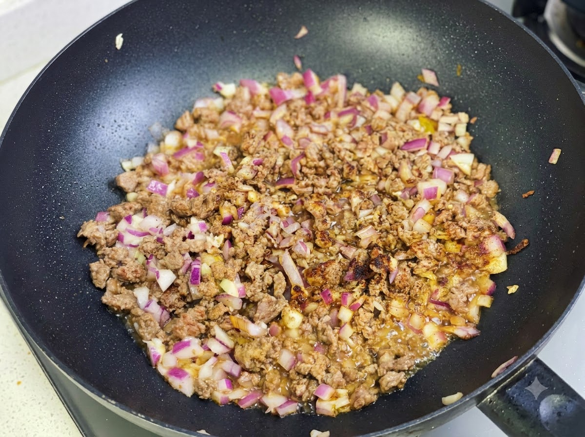 Pasta di curry e spezie saltate con il composto di manzo e cipolla nella padella.
