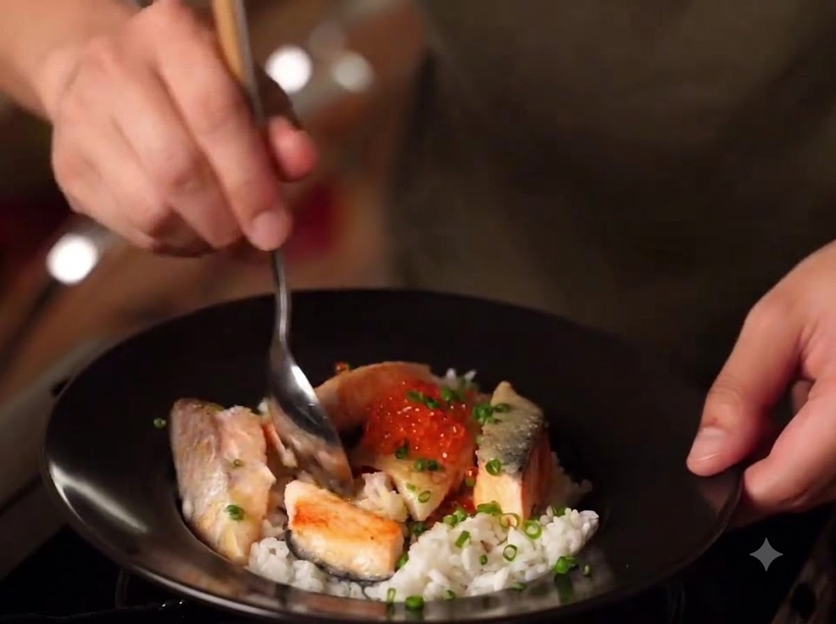 Un primo piano di una ciotola finita di Miso Salmon Oyakodon con riso, salmone scottato, uova di salmone e cipollotti.
