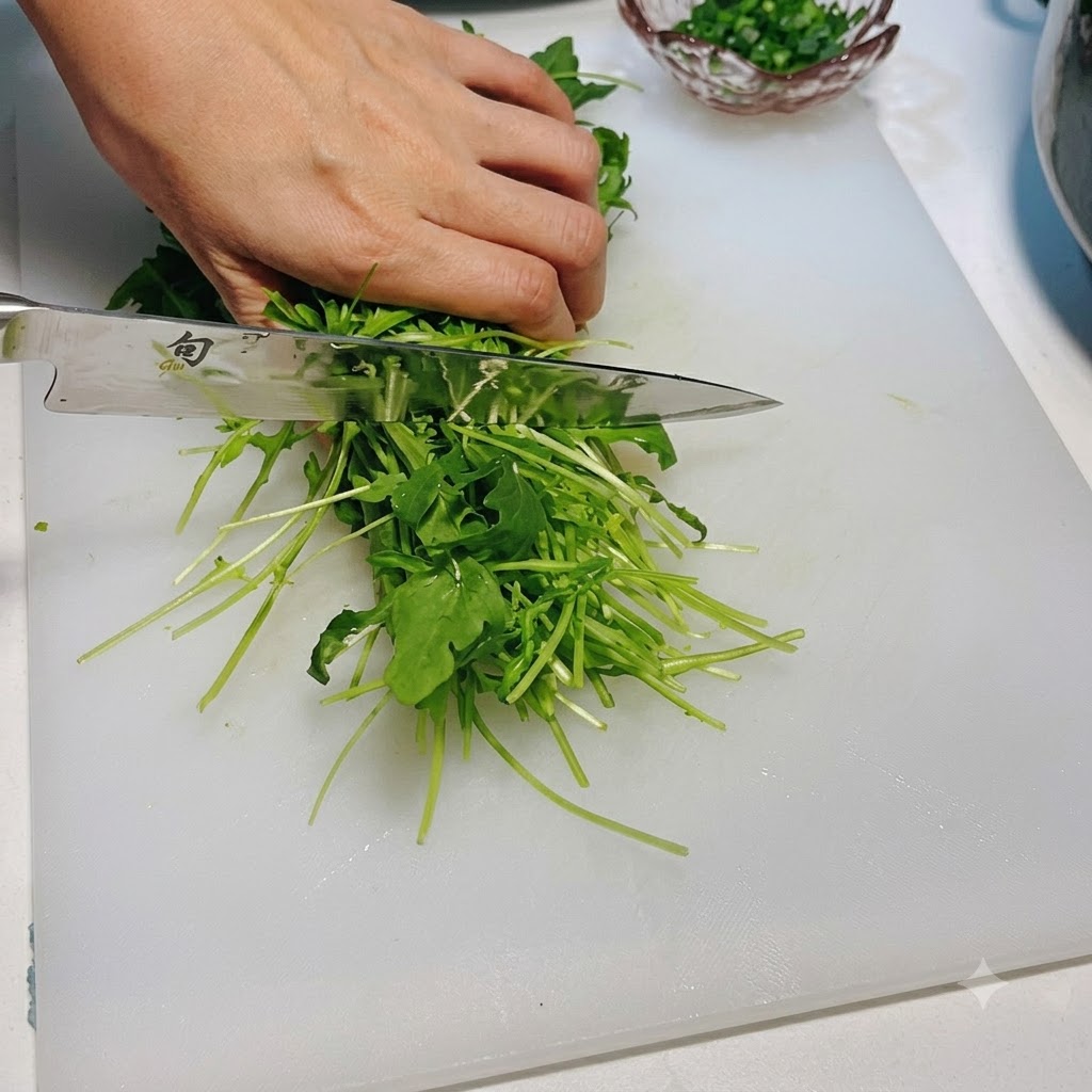Rucola fresca tagliata con un coltello su un tagliere bianco.
