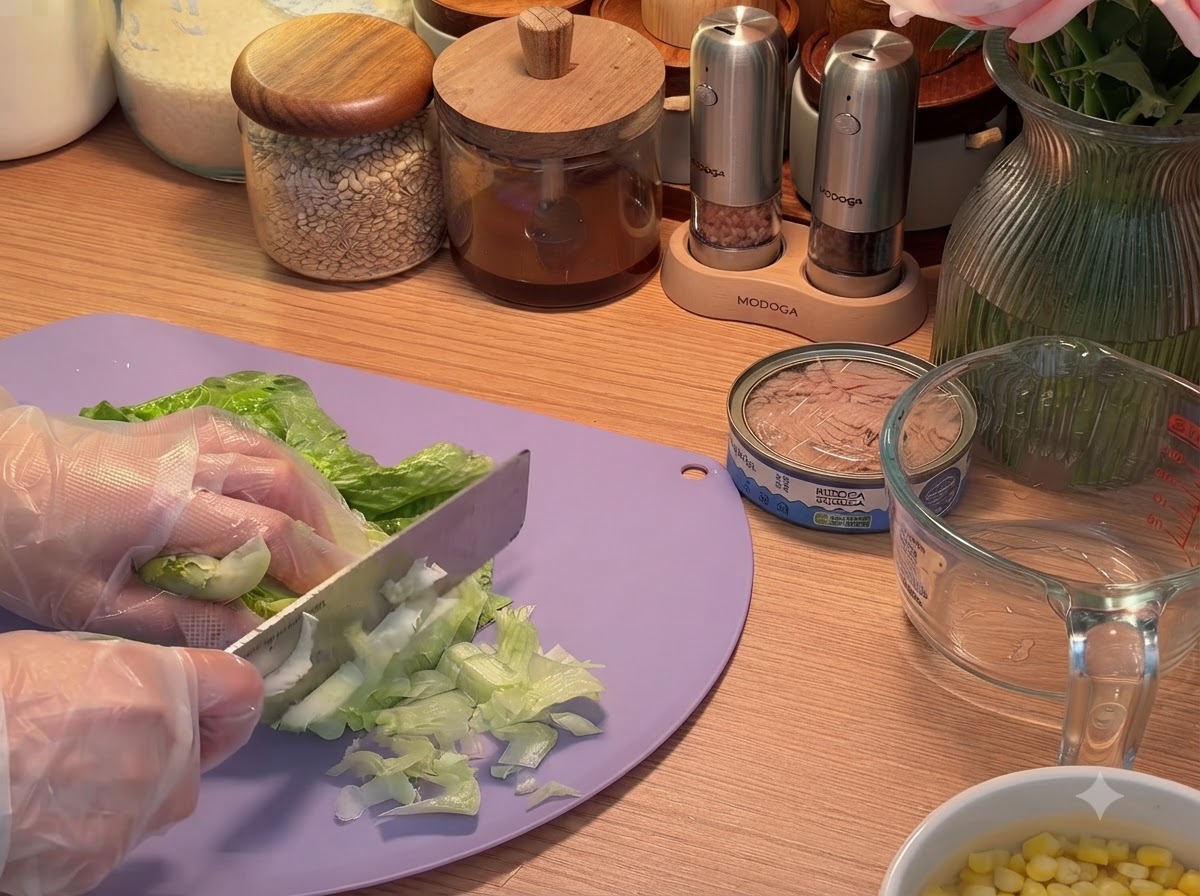 Foglie di insalata tagliate a striscioline su un tagliere con un coltello.
