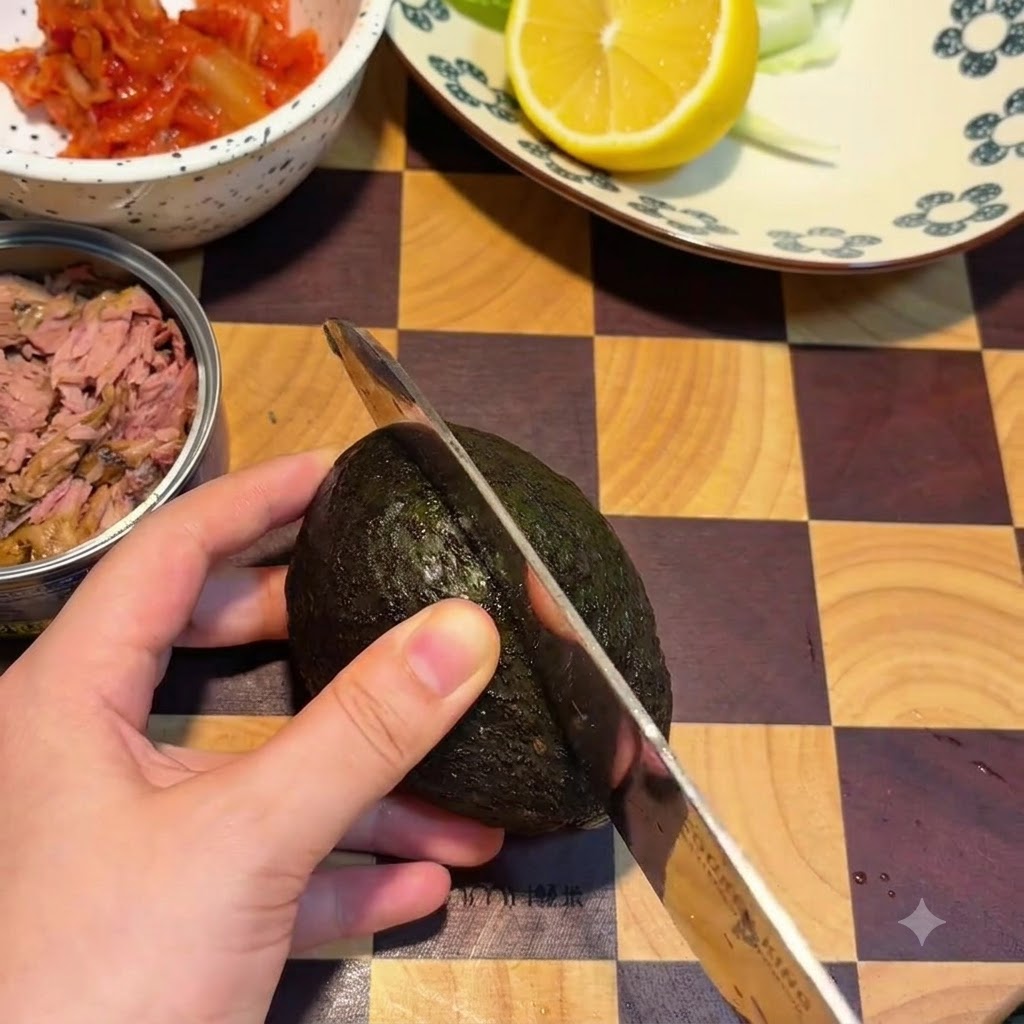 Un avocado tagliato a metà per il lungo su un tagliere di legno con un coltello.