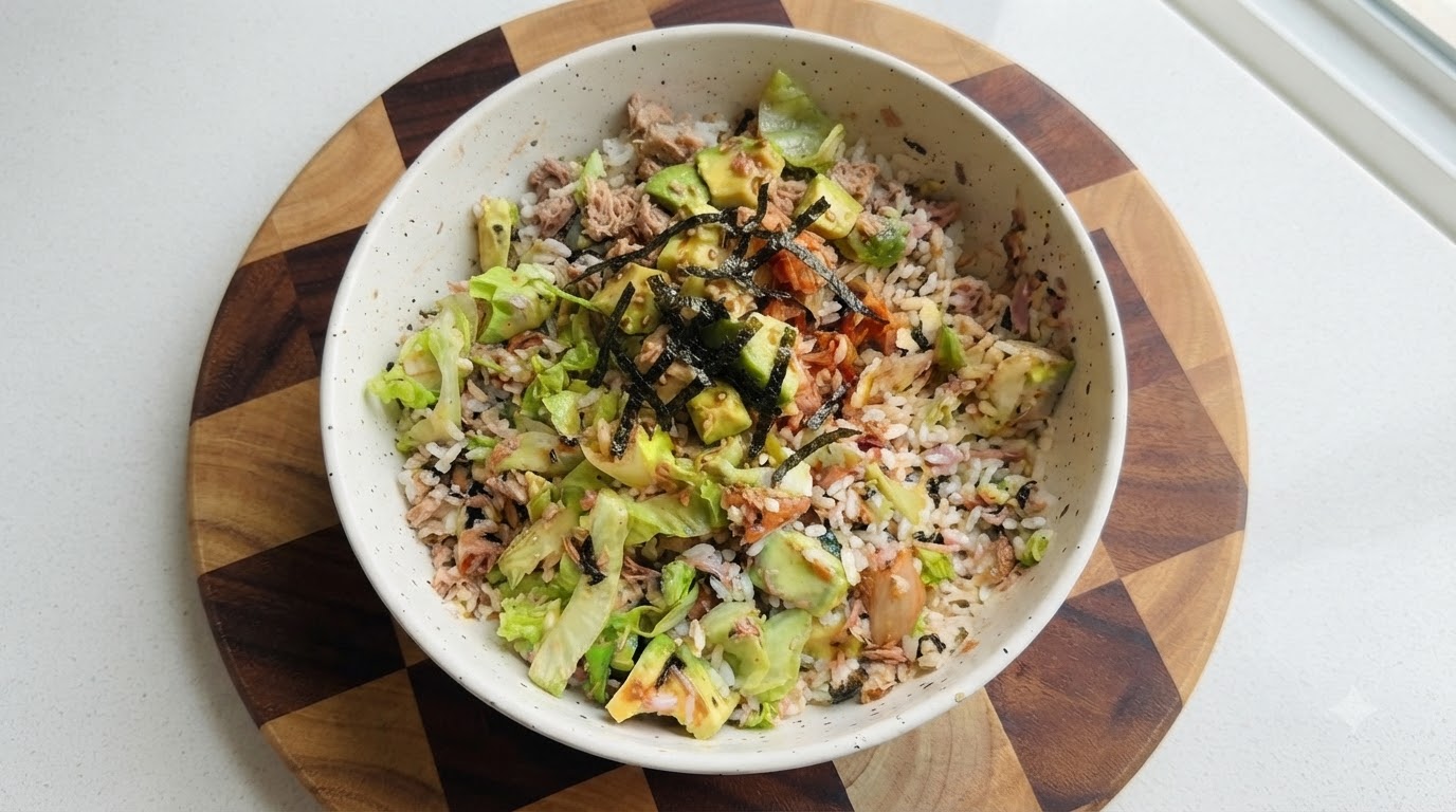 Una vivace bowl di riso senza cottura guarnita con tonno a scaglie, avocado cremoso, lattuga croccante, kimchi e alghe.