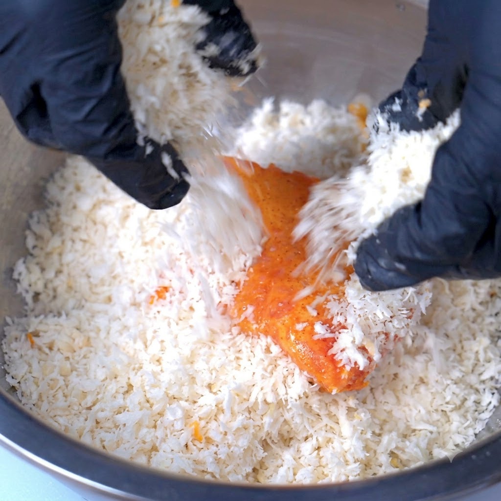 Una cotoletta di maiale ricoperta da un spesso strato di pangrattato allinterno di una ciotola capiente.