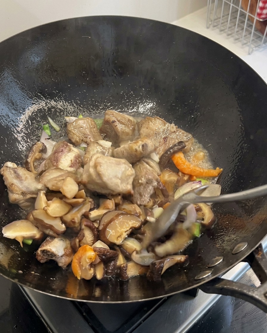 Carote a dadini e chicchi di mais mescolati al contenuto sfrigolante del wok.