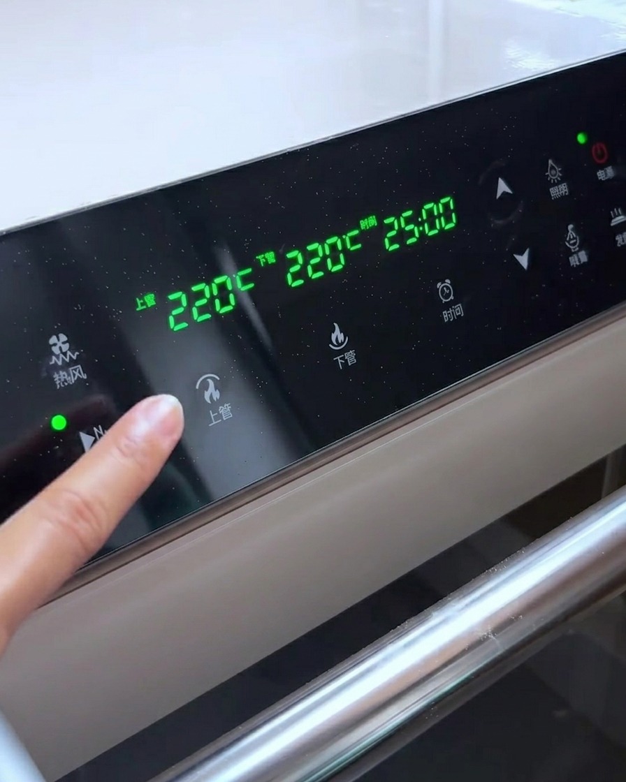 Pannello di controllo del forno che mostra impostazioni di temperatura di 230 gradi per gli elementi superiori e 220 gradi per quelli inferiori.