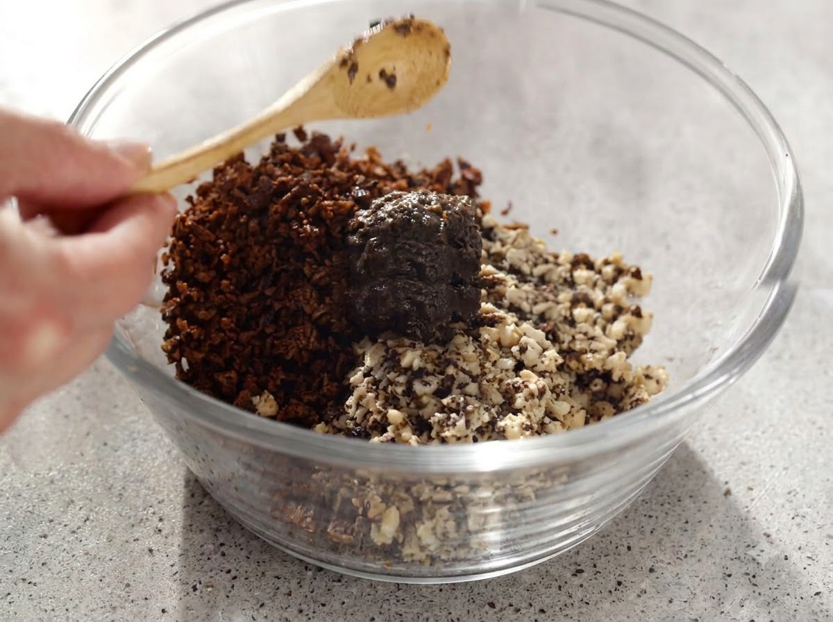 Pasta di tartufo e funghi tritati mescolati accuratamente in una ciotola di vetro con un cucchiaio di legno.