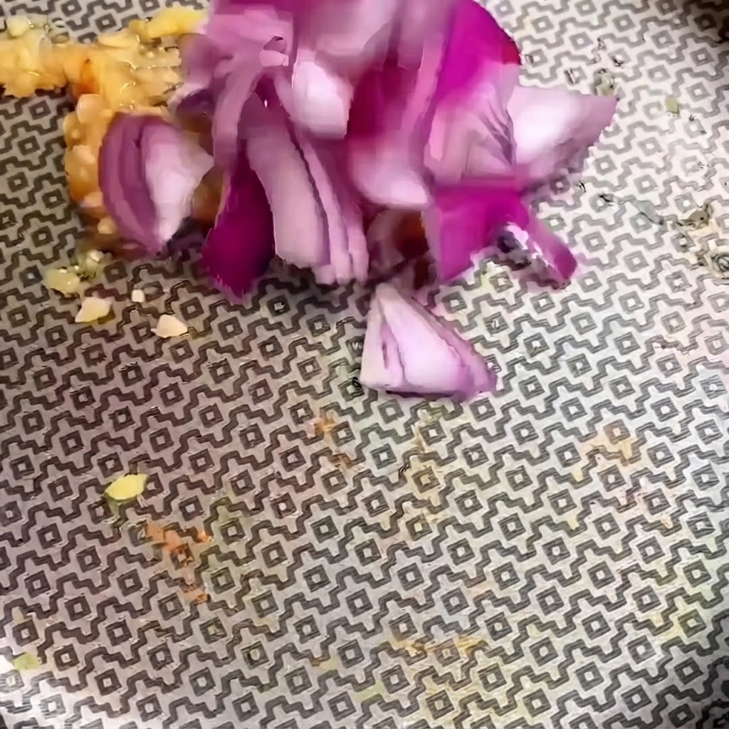 Pezzi di cipolla rossa tritata aggiunti allaglio tritato in una padella fantasia.