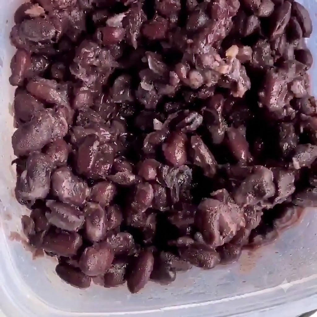 Fagioli neri cotti allinterno di un contenitore di plastica pronti per essere schiacciati.
