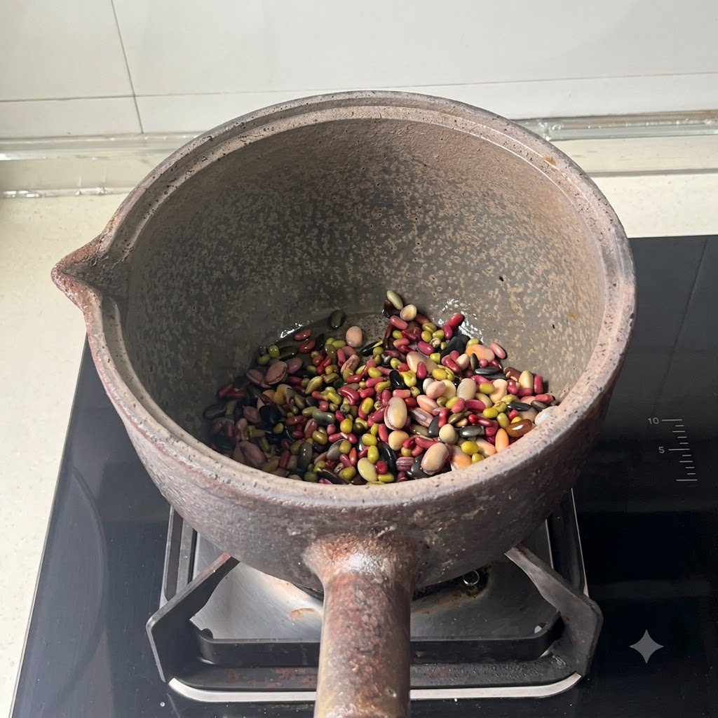 Fagioli misti sul fondo di una pentola di terracotta dopo laggiunta dellacqua.
