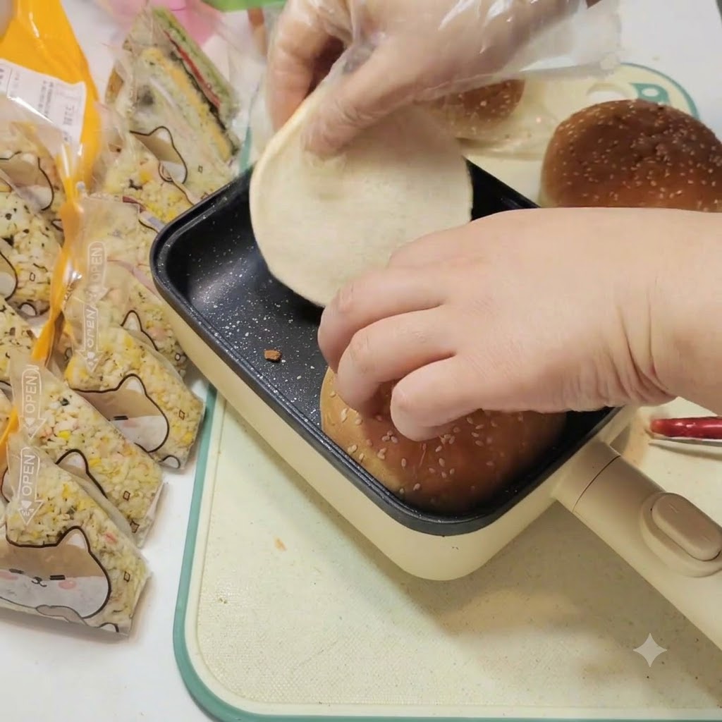 Panini da hamburger riscaldati delicatamente allinterno di una padella quadrata nera con fondo piatto.