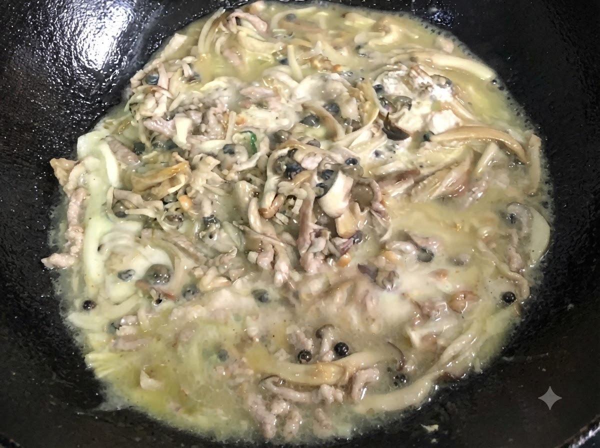 Un composto denso e bollente mescolato continuamente allinterno di un wok nero.
