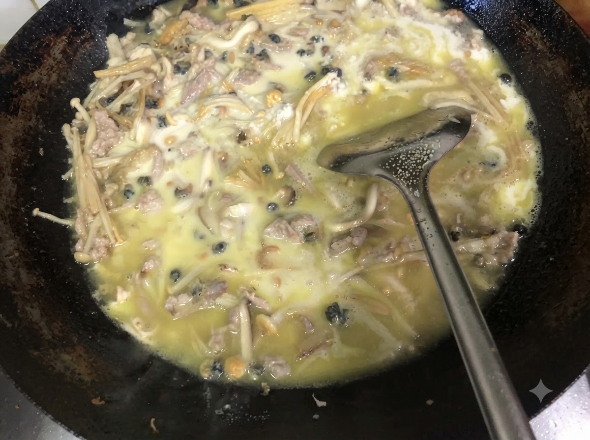 Erba cipollina verde fresca tritata mescolata nel ripieno denso e cotto allinterno di un wok usando una spatola di metallo.