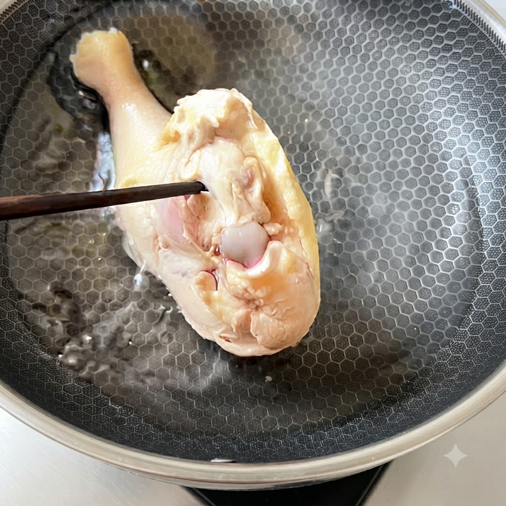 Una sovracoscia di pollo sbollentata rimessa nellacqua fredda allinterno di una padella.