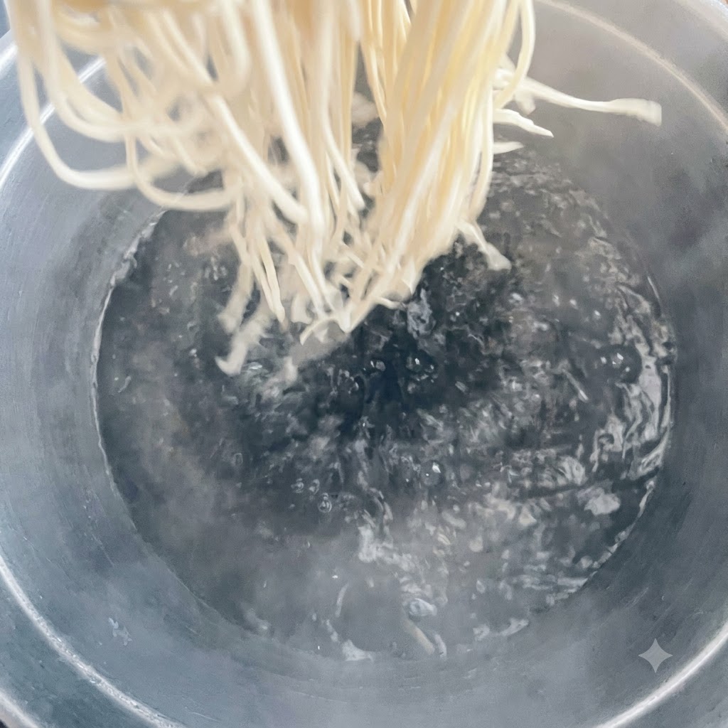 Noodles che vengono immersi in una grande pentola di acqua bollente.