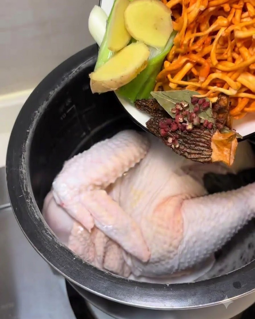 Versamento degli aromi e dei funghi preparati nella pentola del cuociriso con il pollo.