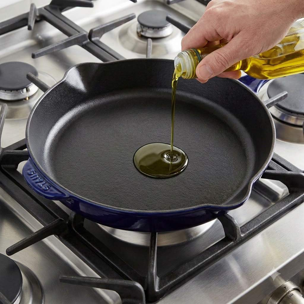 Olio doliva versato in una padella di ghisa preriscaldata.