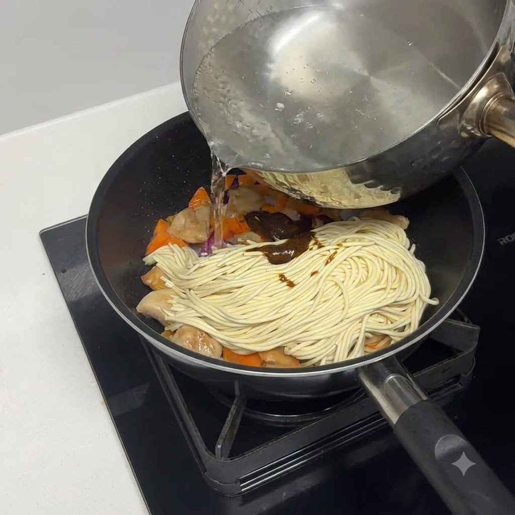 Acqua bollita versata nella padella sopra la pasta e gli ingredienti.
