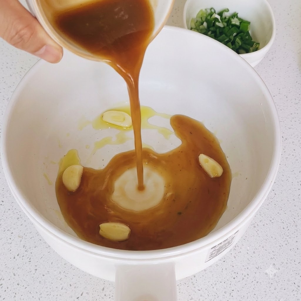 Miscela di salsa bruna versata in una padella con fette di aglio saltate.