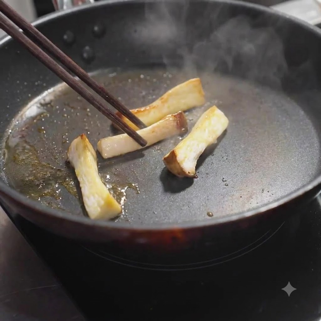 Fette di funghi cardoncelli girate nella padella con le bacchette fino a doratura.