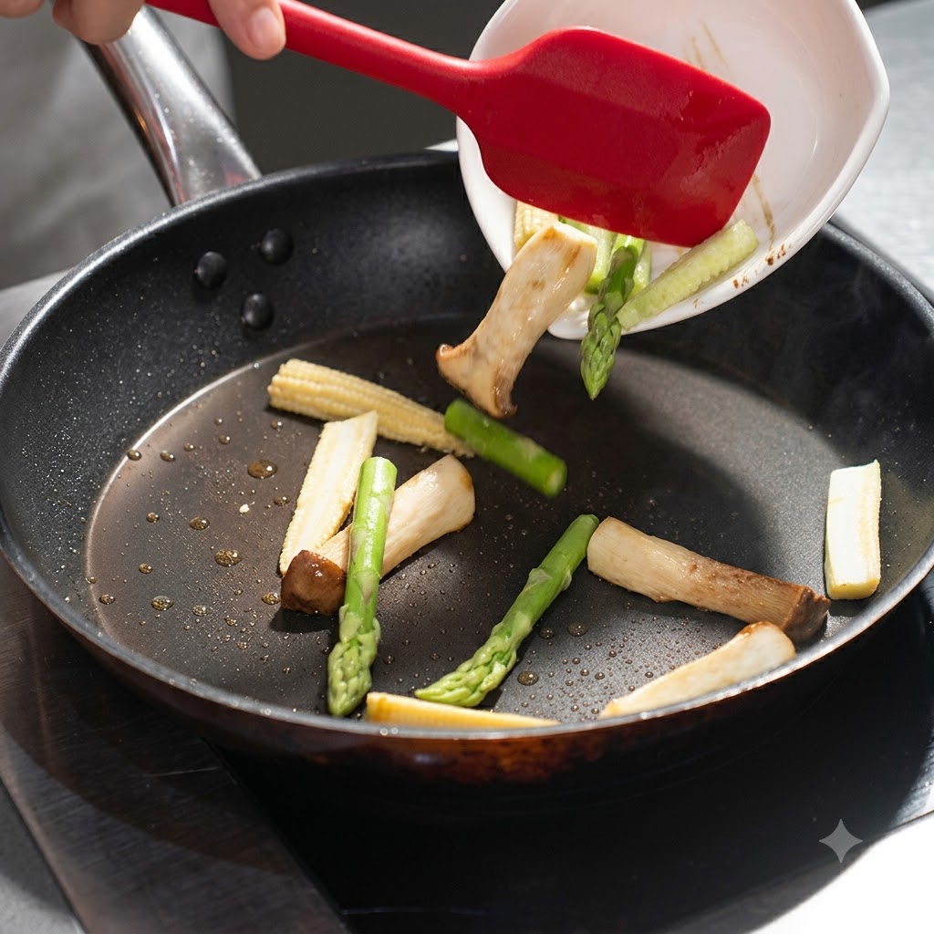 Asparagi e baby corn versati da un piatto bianco nella padella con i funghi.
