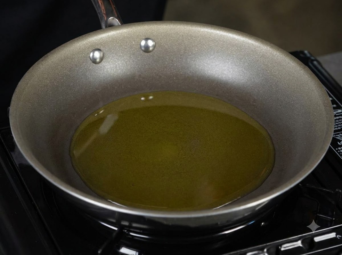 Una padella piena di olio doliva riscaldato appoggiata su un fornello.