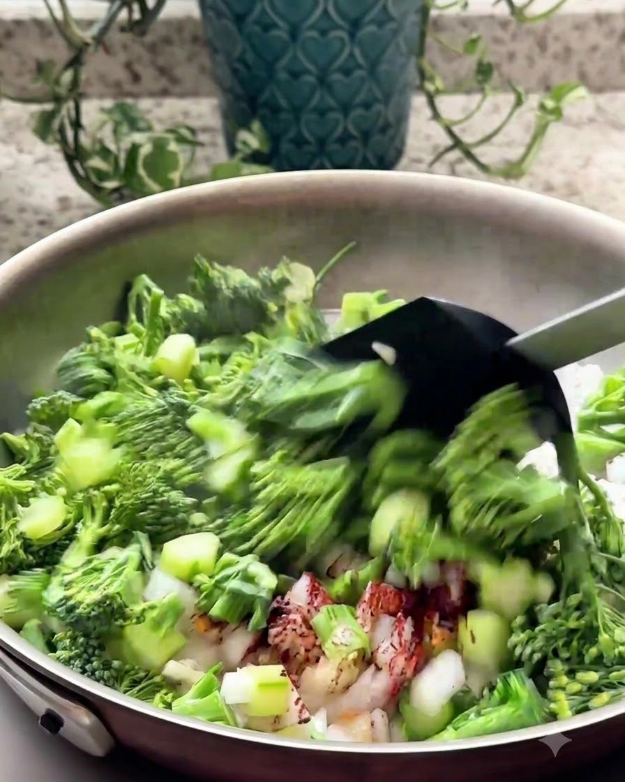 Broccoli tritati e aromi saltati in padella con una spatola nera.