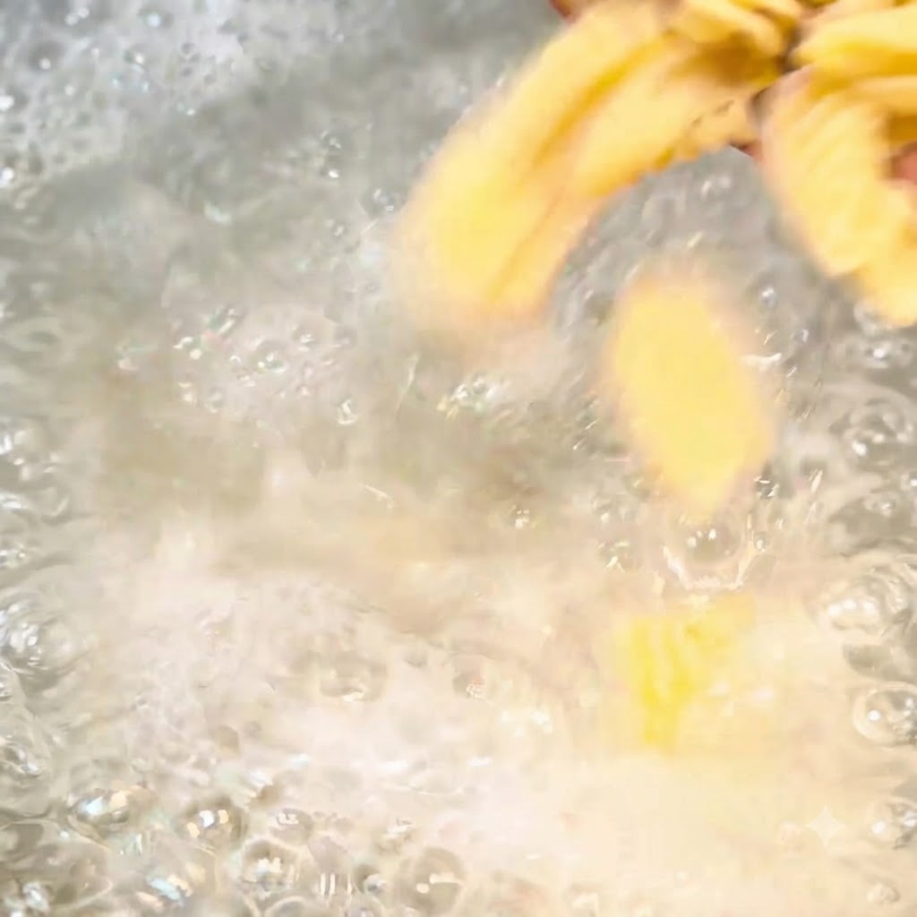 Pezzi di pasta a spirale che bollono vigorosamente in una pentola di acqua salata.