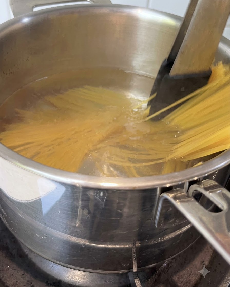 Spaghetti mescolati con le pinze in una pentola di acqua bollente.