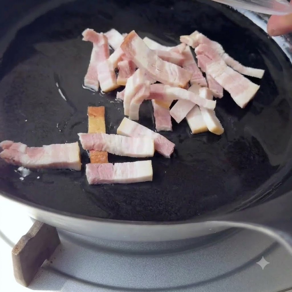 Piccole strisce di pancetta messe in una padella nera con olio caldo.