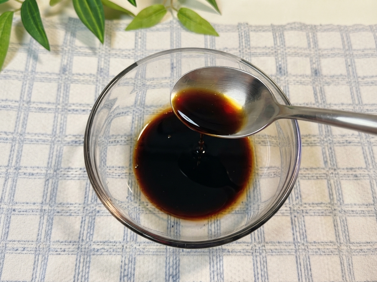 Salsa di soia e altri condimenti mescolati dentro una ciotola di vetro con acqua.